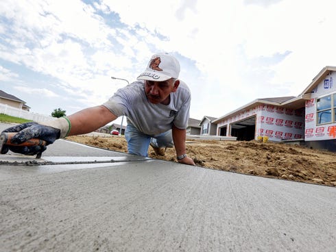 A sidewalk gets shaped in front of new home construction in Omaha, Neb.