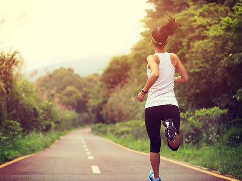 A woman runs on a nature trail.