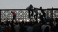 Palestinians at the border of the Gaza Strip climb over a gate as they try to cross into Egypt.