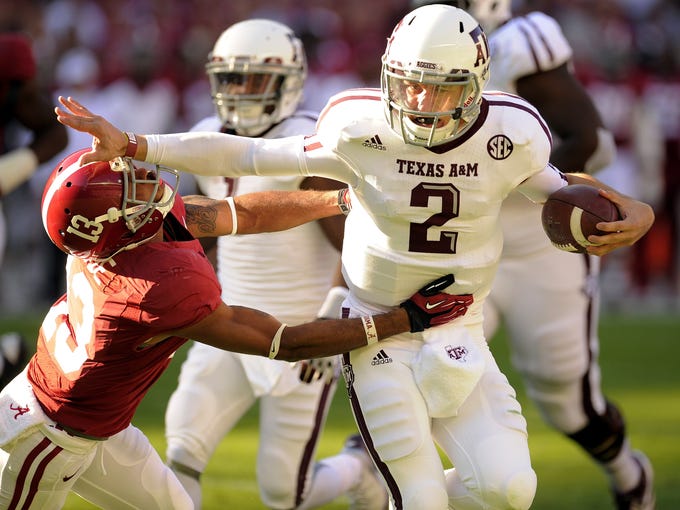 Manziel (2) stiff arms Alabama defensive back Deion Belue.