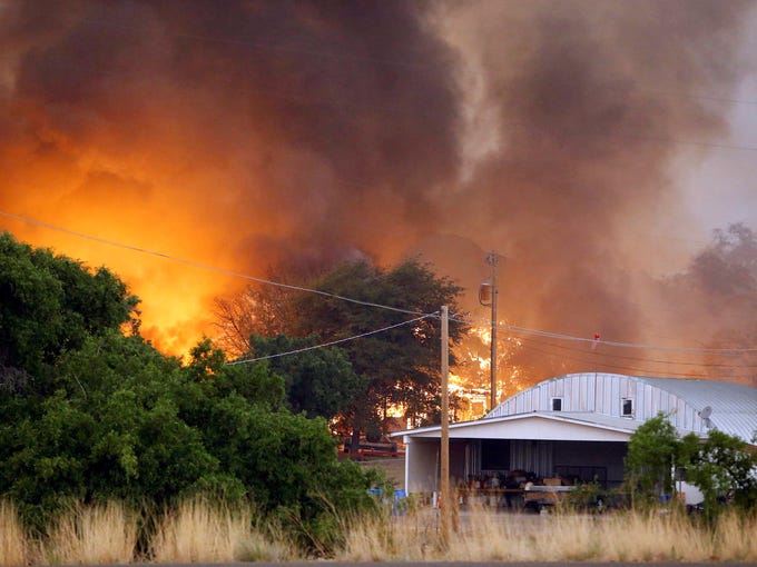 Homes burn as a fire approaches Glenn Ilah on June 30 in Yarnell, Ariz.