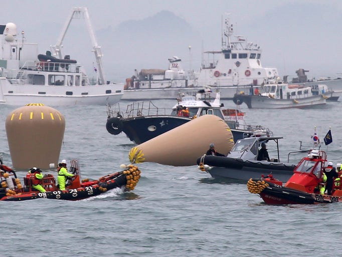 South Korean Navy officials work on buoys to mark the sunken passenger ferry Sewol in the water off the southern coast near Jindo, South Korea.