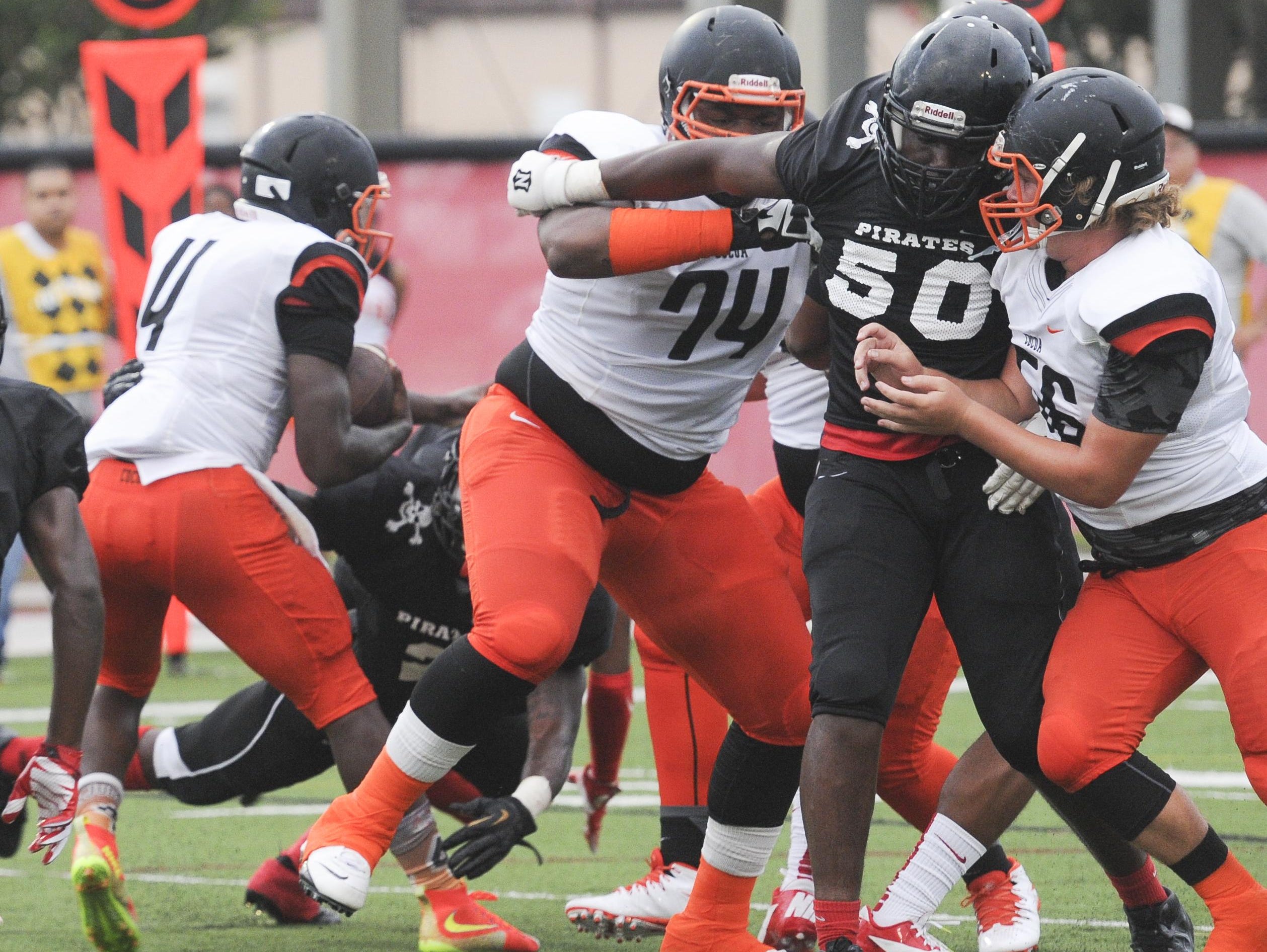 Zack Brasher (56) and Jawaan Taylor (74) block for Cocoa QB Bruce Judson during Friday's gama against Palm Bay.