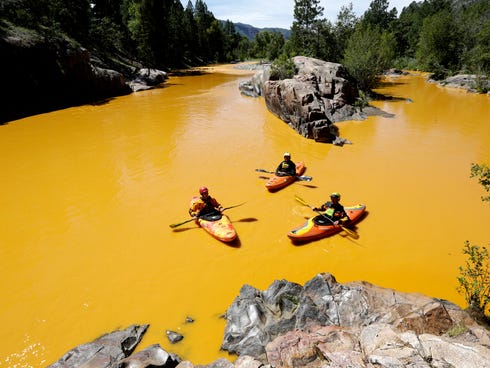 People kayak in the Animas River near Durango, Colo., Aug. 6, 2015, in water colored from a mine waste spill. The U.S. Environmental Protection Agency said that a cleanup team was working with heavy equipment Wednesday to secure an entrance to the Go