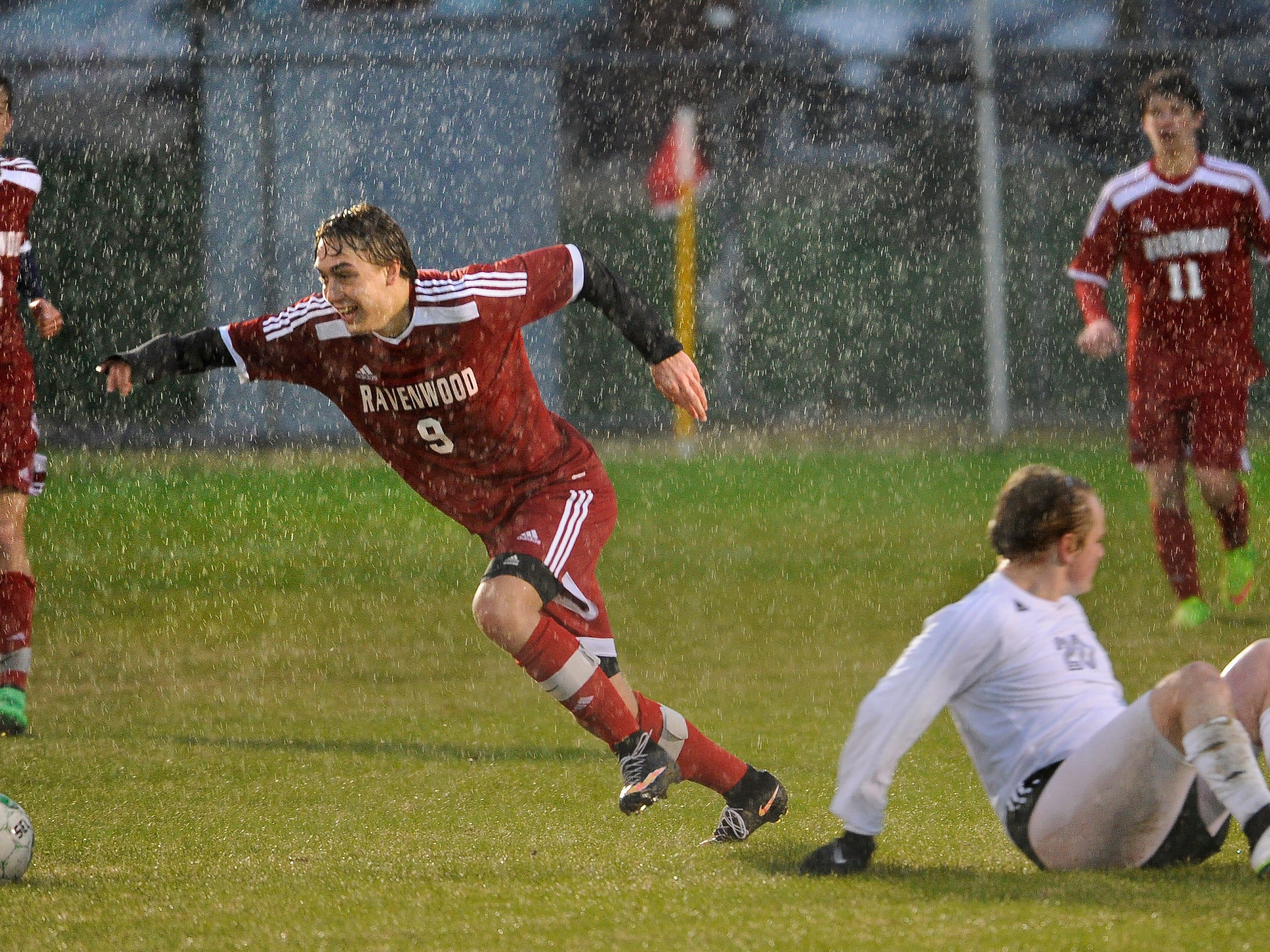 Ravenwood’s Sam Knickerbocker goes after the ball after knocking down Independence’s Daniel Robinson during a rain-soaked soccer match recently.