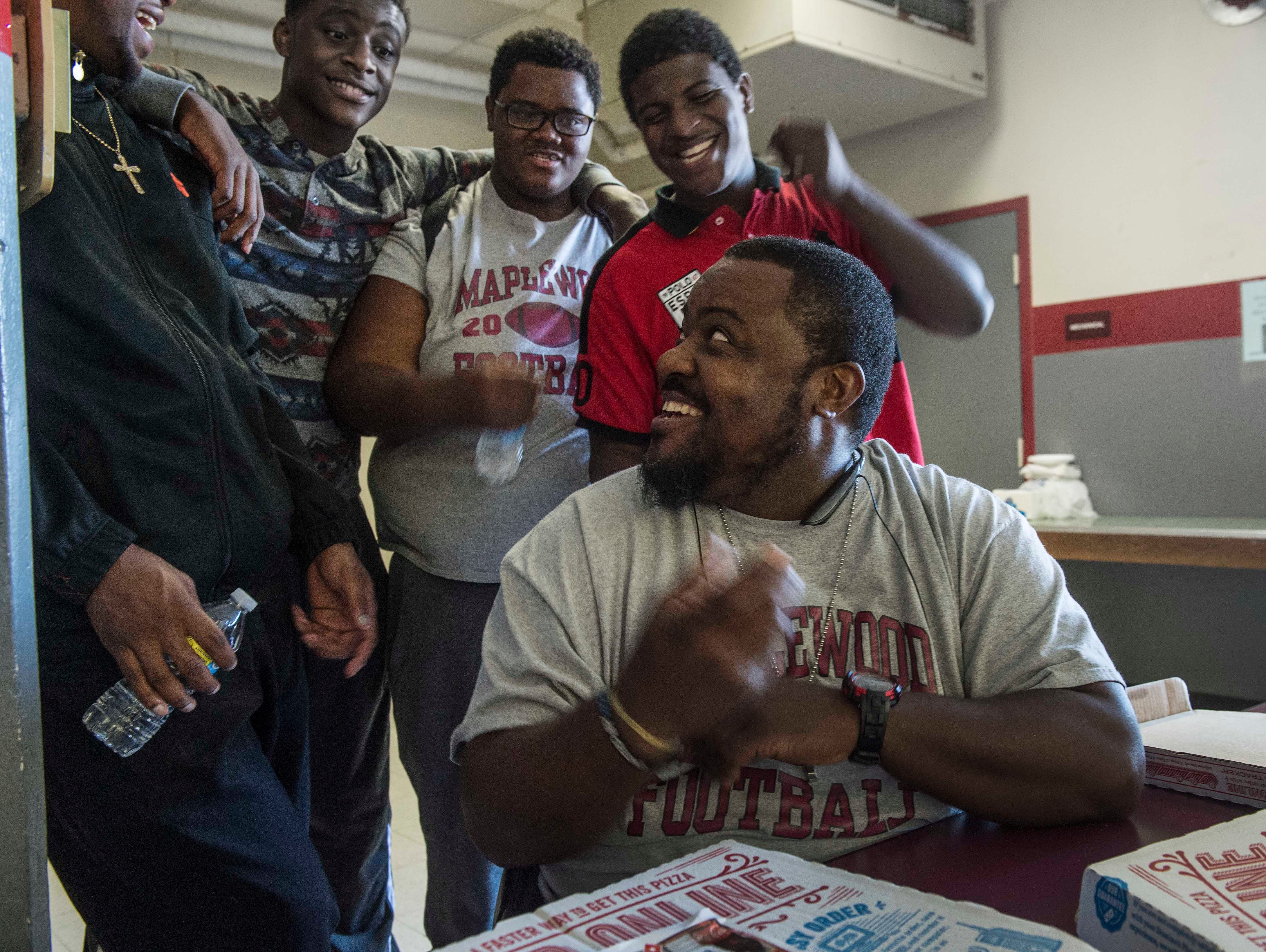 Maplewood head football coach Arcentae Broome jokes with some of his players after school as meals were served by the Fellowship of Christian Athletes at Maplewood High School on Oct. 16.