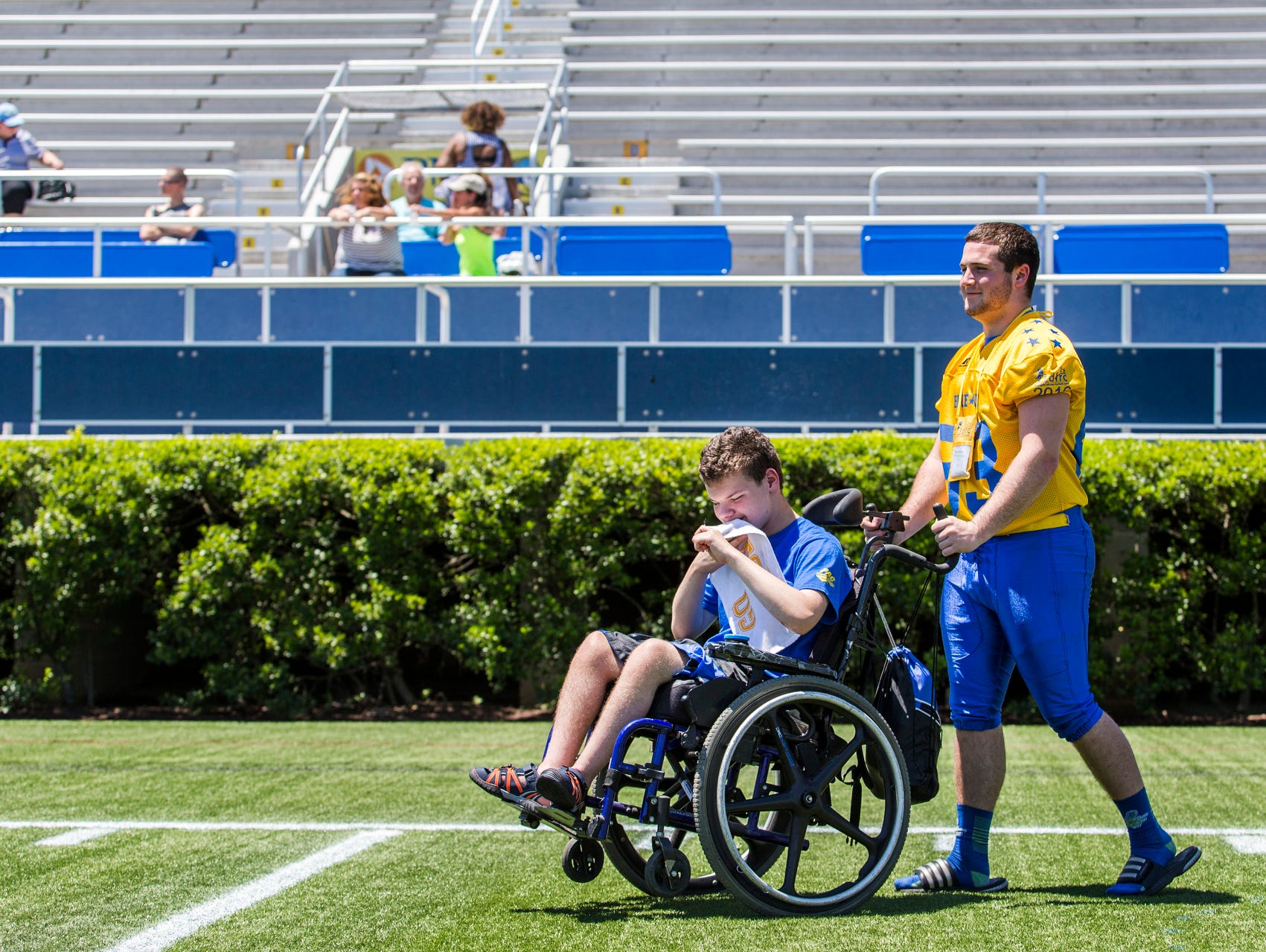 Brady Abraham pushes Sean Burke around the field during the Blue-Gold Football media day at Delaware Stadium in Newark on Sunday afternoon.