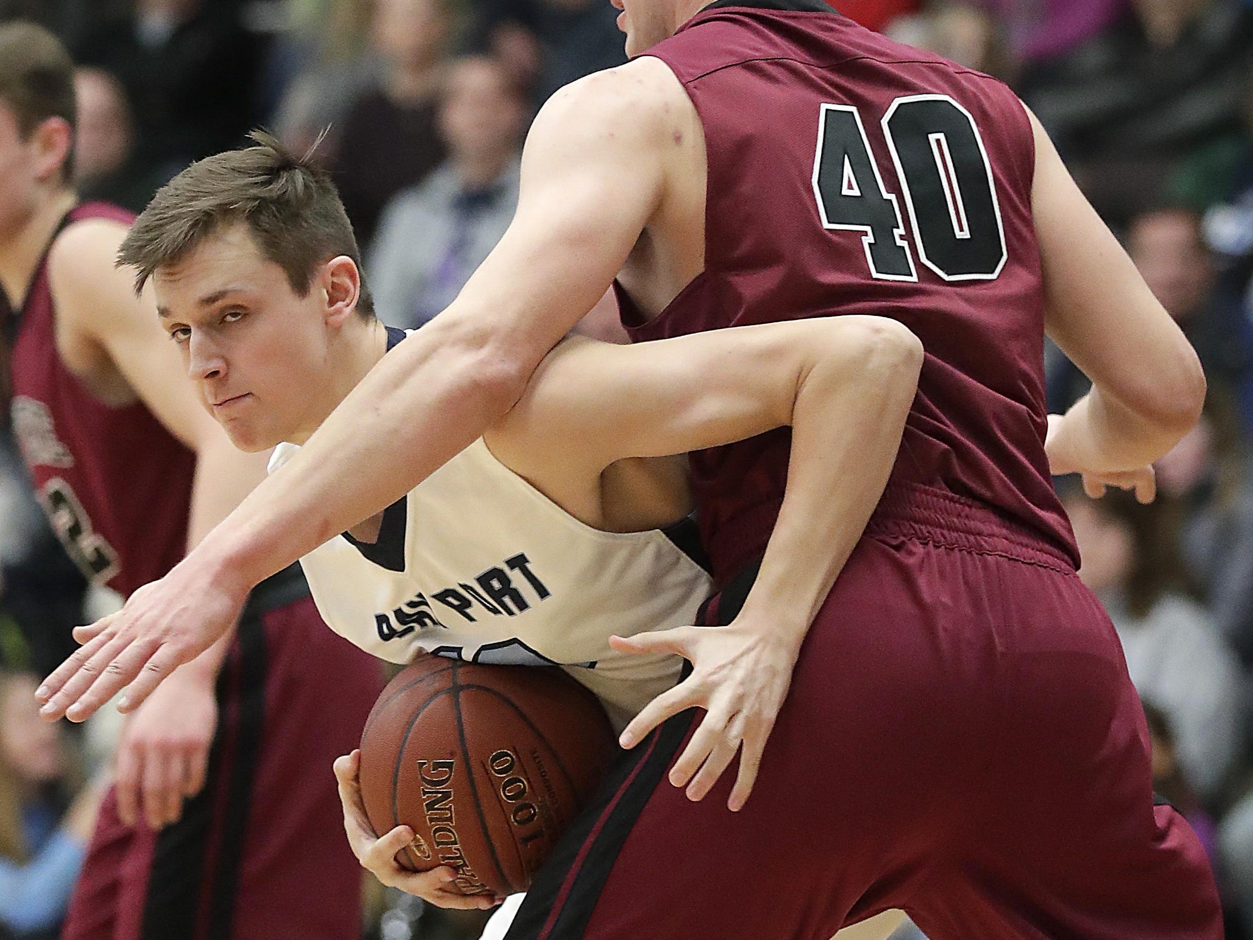 Bay Port’s Cade Johnson hooks around De Pere’s Max Huddleston at Bay Port on Friday.