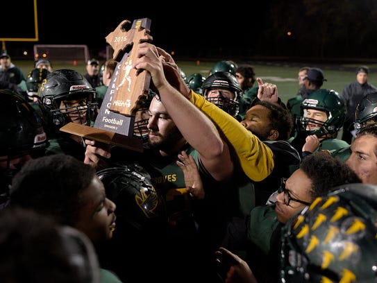Groves players hold up the regional championship trophy
