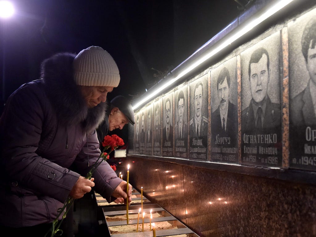 People set candles and lay flowers at the monument to Chernobyl victims in Slavutich, some 30 miles from the accident site, during a memorial ceremony early on April 26, 2017.\u000d\u000aUkraine on April 26, 2017, marks the 31st anniversary of the Ch