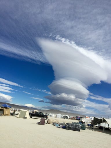 Towering lenticular clouds pile up during a break in