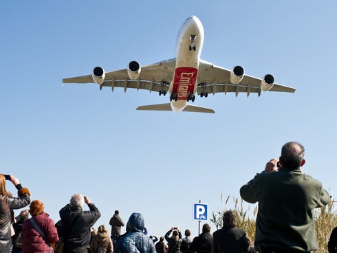 People take pictures as an Emirates Airbus A380 lands at a Barcelona airport on Feb. 24, 2013.