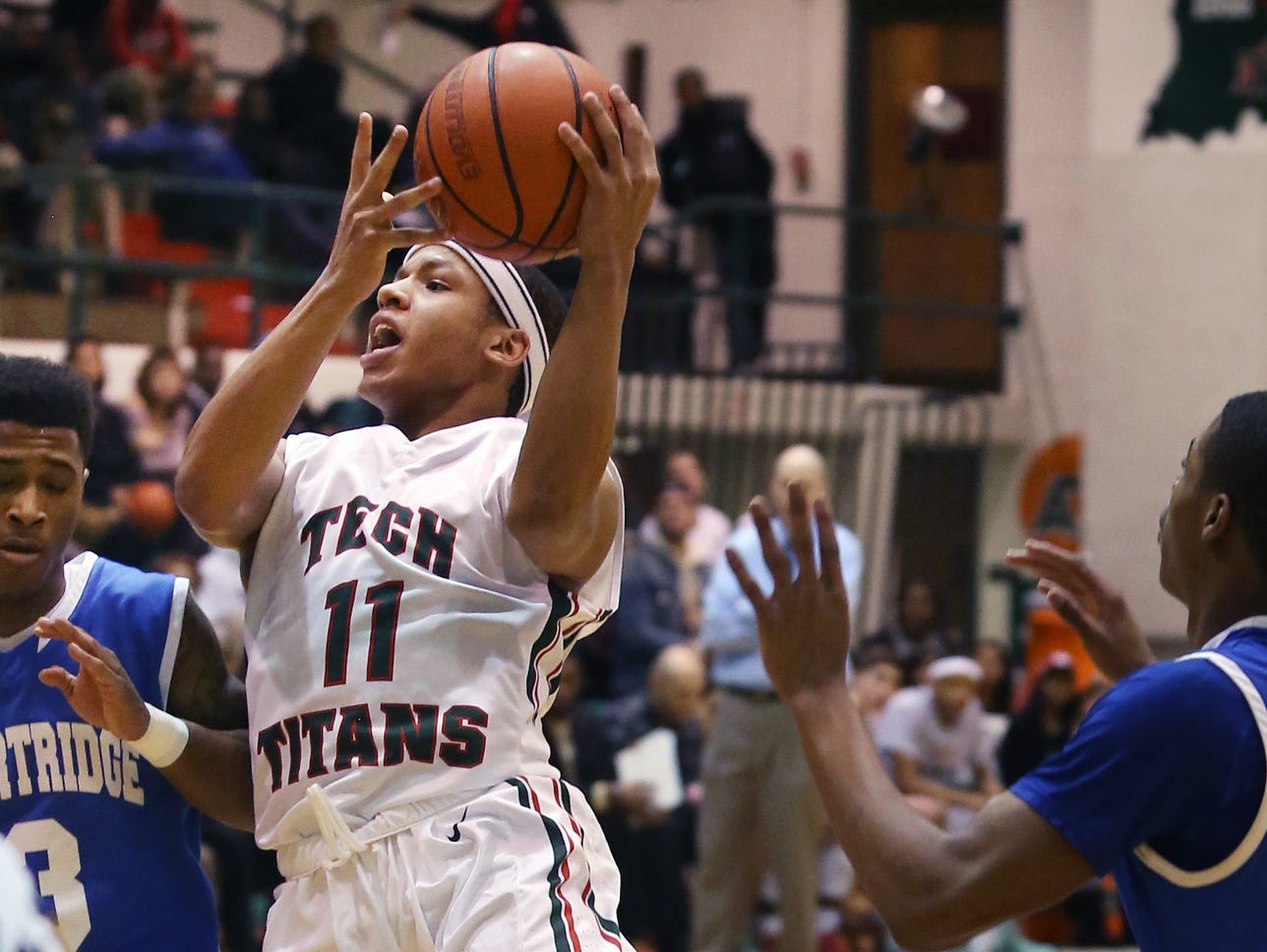 C.J. Walker, Arsenal Tech's leading scorer with 24 points, goes in for a layup against Shortridge Blue Devil Chris Adams, the game's high scorer with 28 points, during the Titans' 70-53 City Tournament quarterfinal win over Shortridge at Tech on Thursday, Jan. 22, 2015.