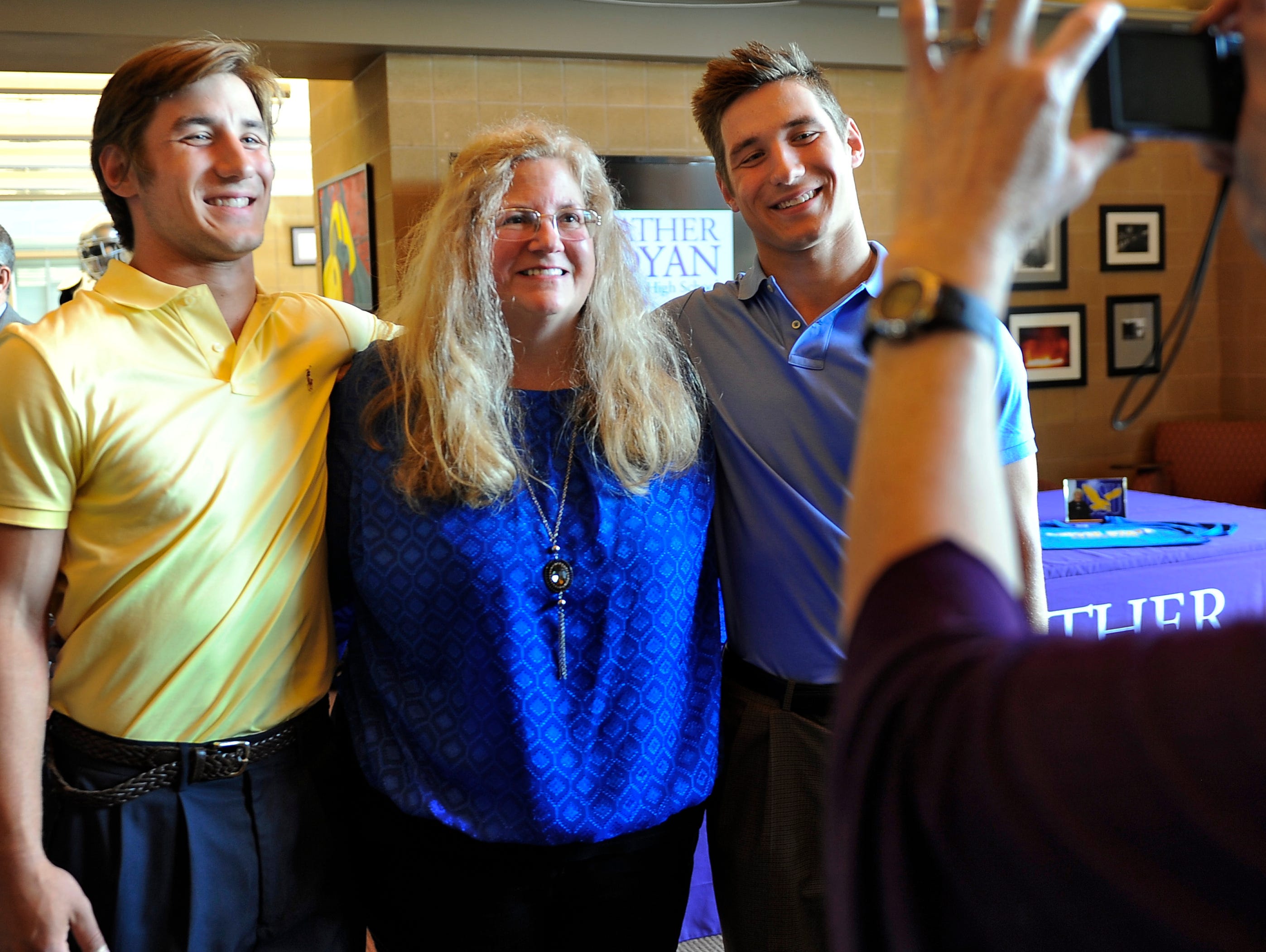Twins Andrew, left, and John O’Dwyer pose for a picture with their mother Alice O’Dwyer before they sign their letters of intent to attend Coppin State University together at Father Ryan High School on Wednesday, May 6.
