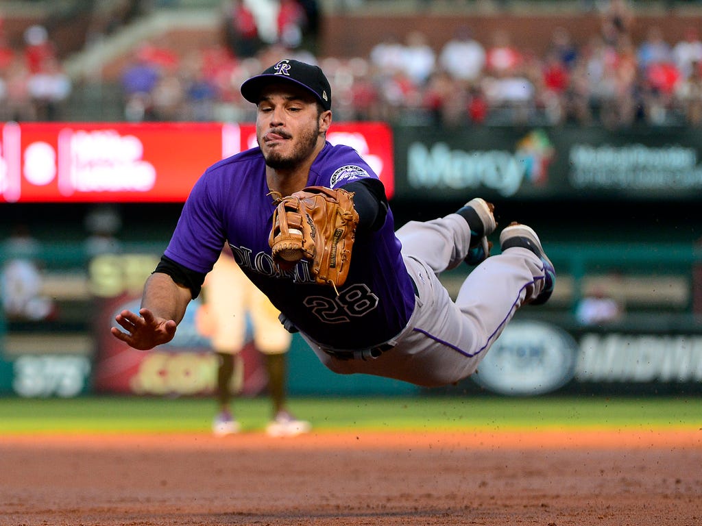 Colorado Rockies third baseman Nolan Arenado dives and catches a line drive hit by St. Louis Cardinals second baseman Kolten Wong during the first inning at Busch Stadium in St. Louis.