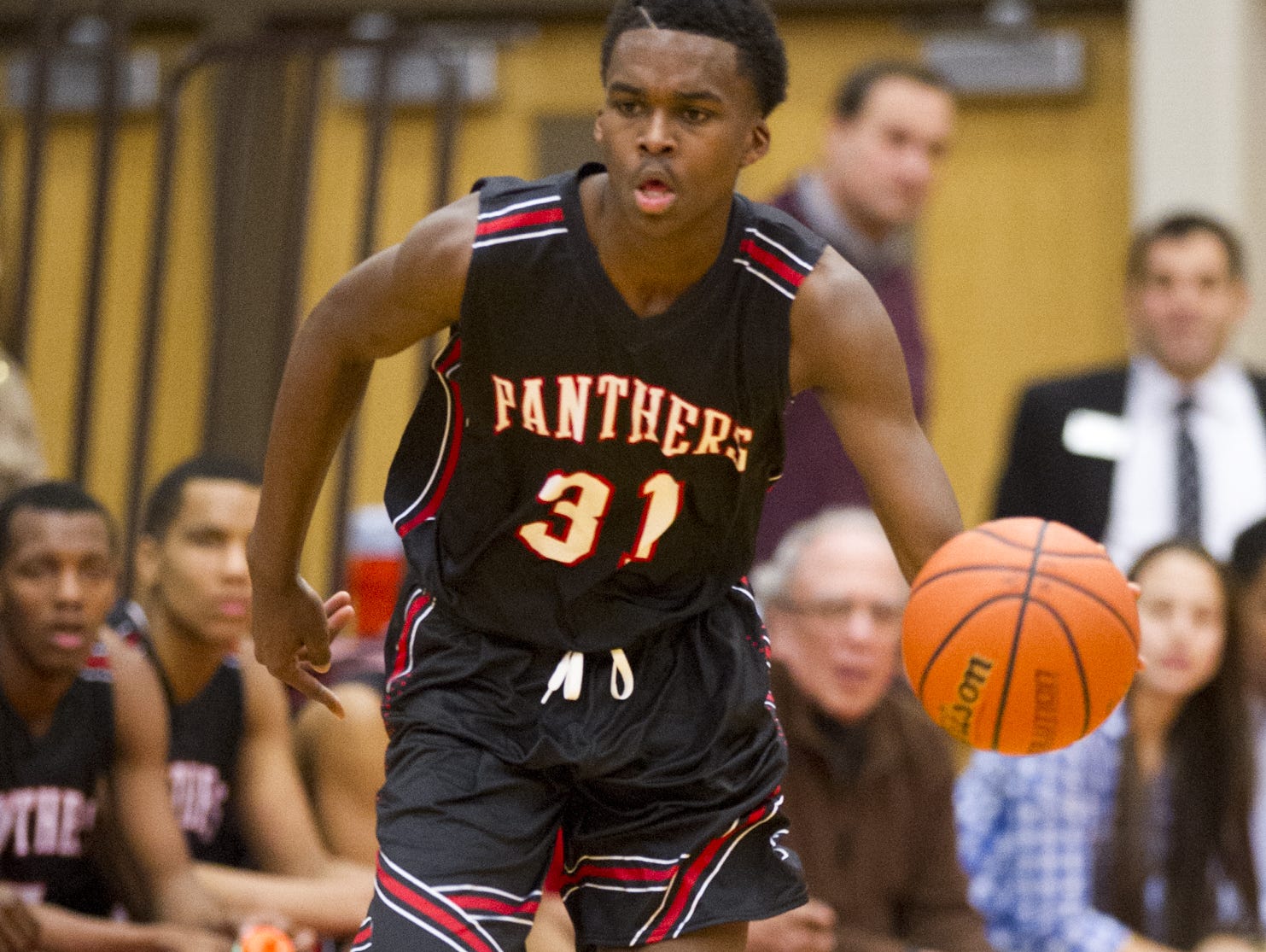 North Central High School sophomore Kris Wilkes (31) brings the ball up court during the first half of action. Lawrence North High School hosted North Central High School in a first-round game of the 2015 Marion County Boys Basketball Tournament, Tuesday, Jan. 13, 2015.