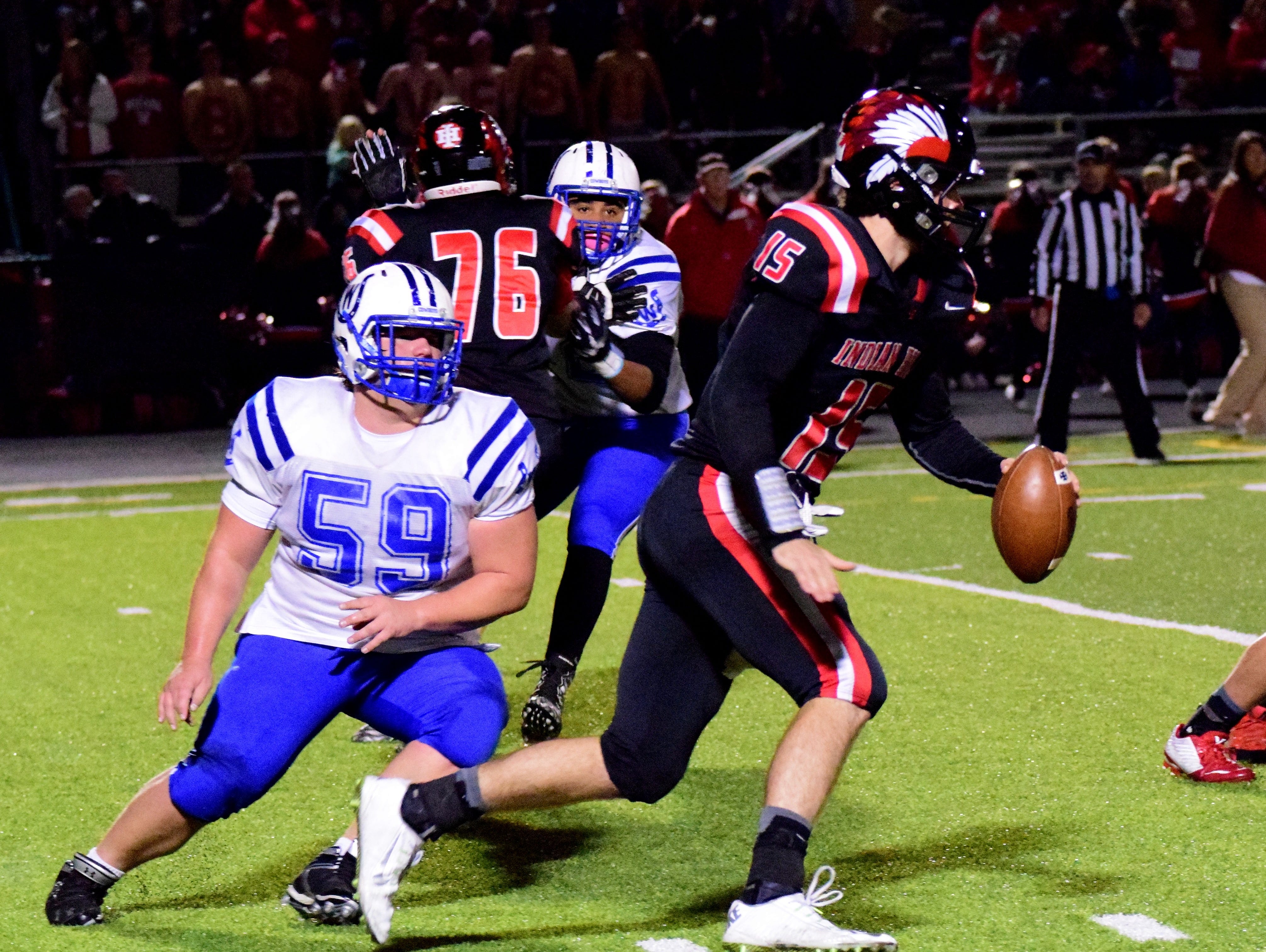 Indian Hill quarterback Reed Aichholz (15) is pressured out of the pocket by Wyoming's Cooper O'Gara (59). November 7, 2015