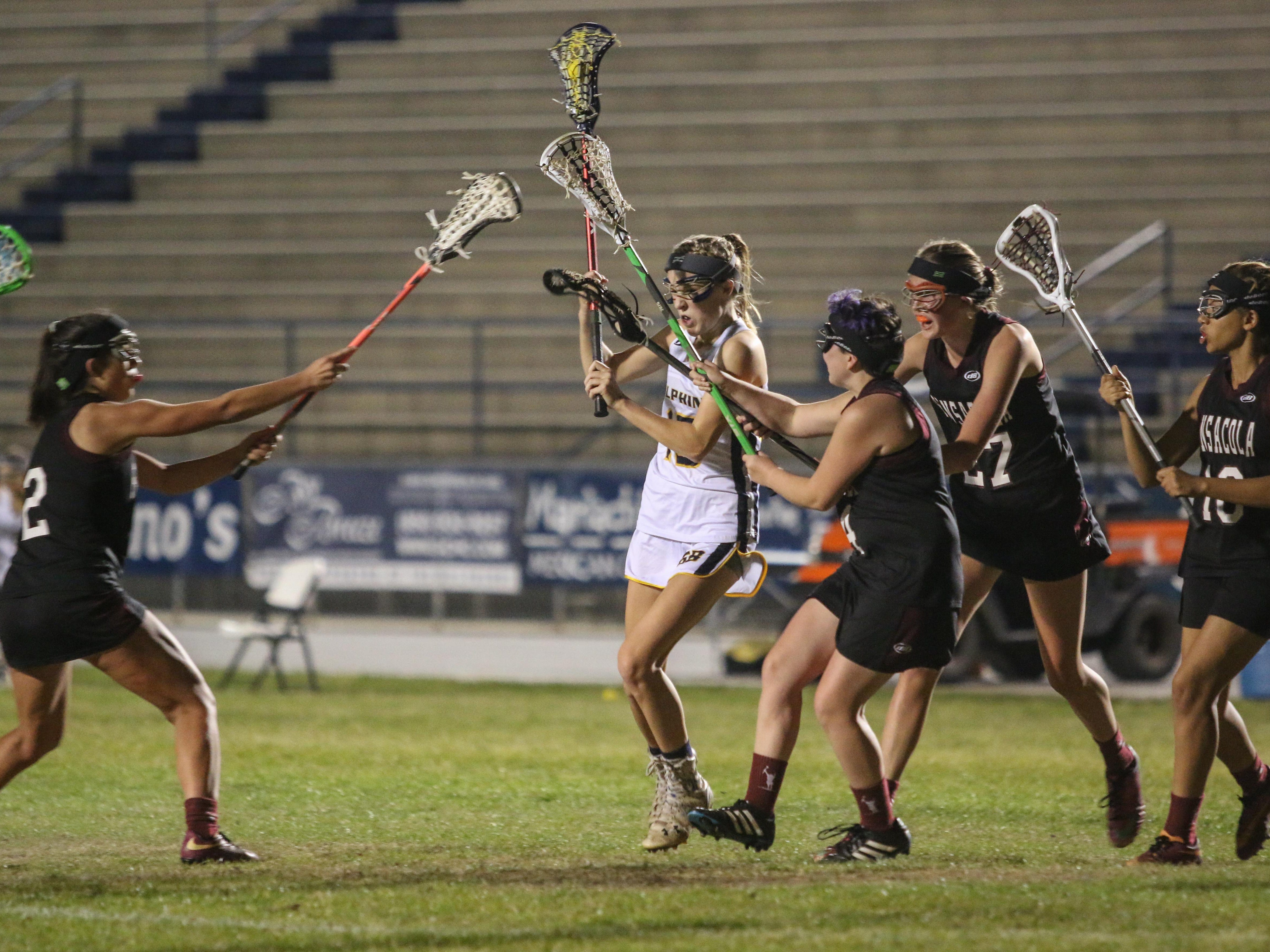 Gulf Breeze's Francis Williams (15) fights her way through the Pensacola players on her way to the goal Thursday night during the District 1-1A girls lacrosse championship game at Gulf Breeze High School.