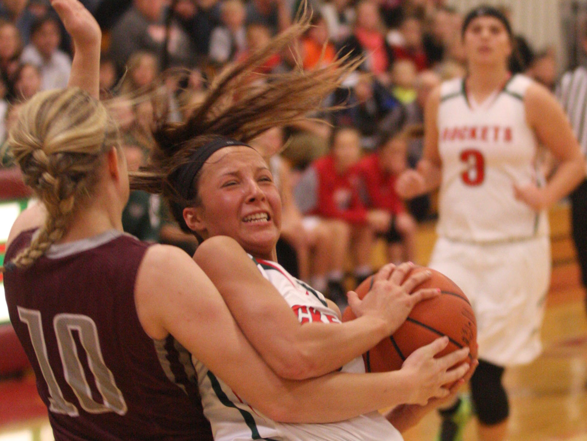 Oak Harbor's Athena Eli tries to maintain her footing and grip on the ball Tuesday against Genoa's Haley Gerke.