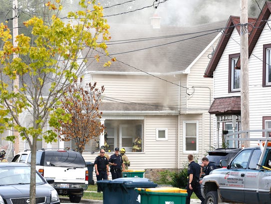 Police and fire officials work the scene of a house