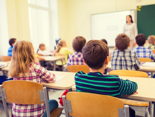 group of school kids and teacher in classroom
