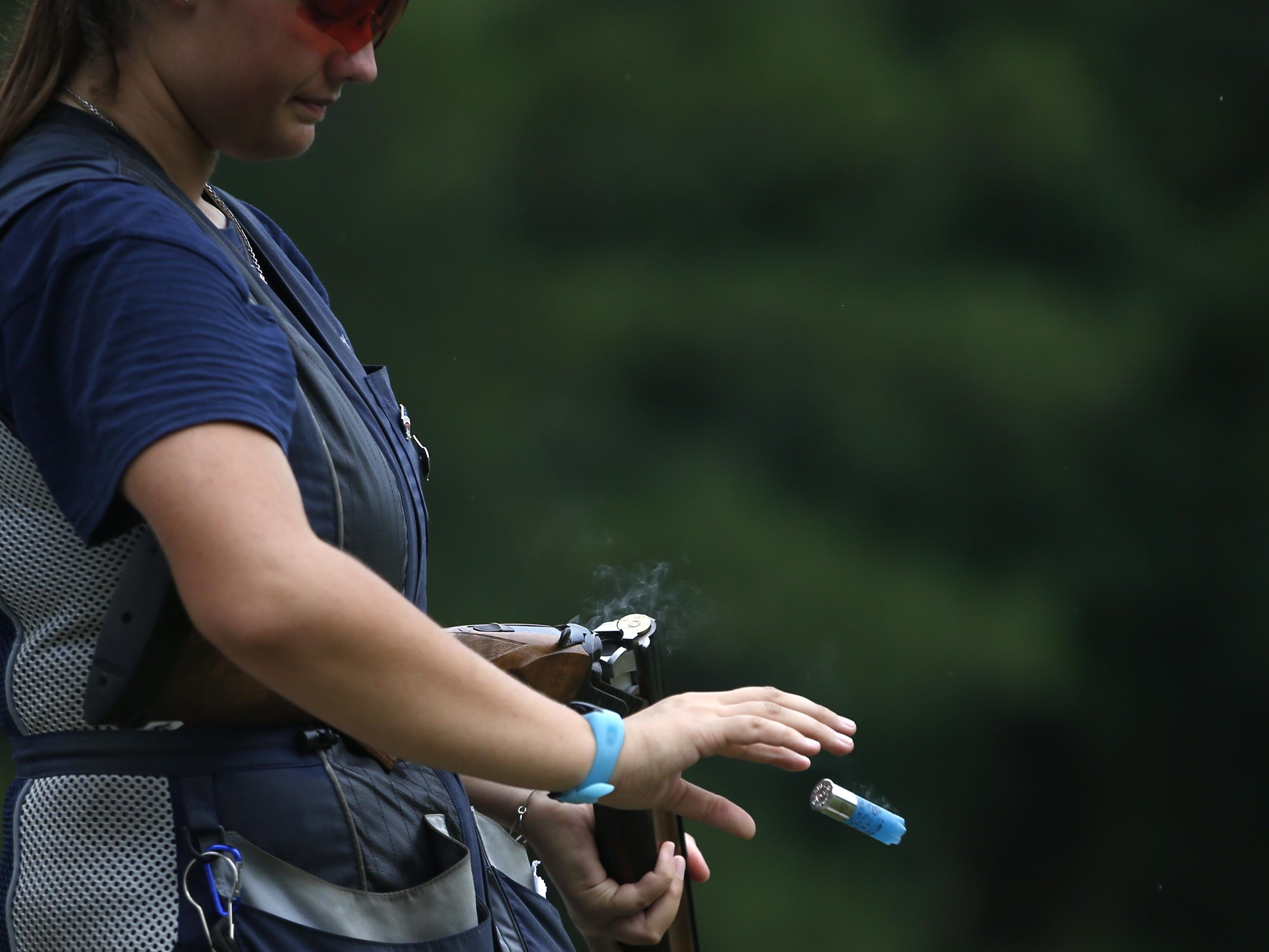 Abby Blakeley tosses an empty shell from her double-barreled shotgun after shooting at Bridge Creek Clays South Georgia Youth Shooting Club's clay pigeon range on Tuesday, June 30, 2015.