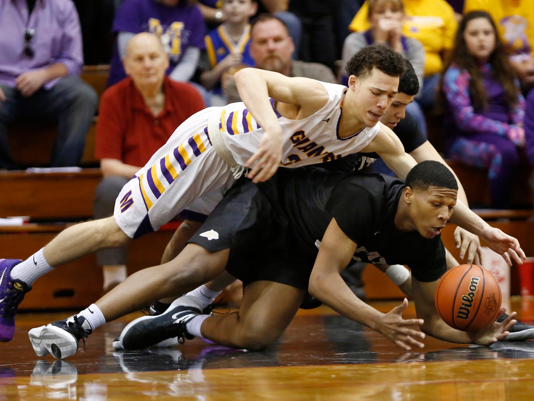 Marion's Tim Leavell, top, and Griffith's Cornell Hampton dive for a loose ball in the Class 3A basketball semistate Wednesday, March 23, 2016, Lafayette Jefferson High School. Marion defeated Griffith 60-58.