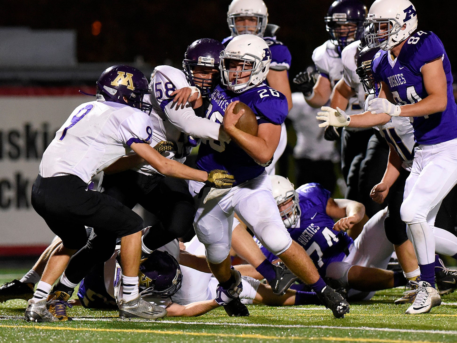 Albany's Will Kleinschmidt makes a short gain before being brought down by Montevideo's Preston Herfurth (9) and David Nelson (58) during the first half Saturday, Oct. 24 at Husky Stadium.