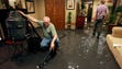 T. W. Hale, left, helps his friends by vacuuming water