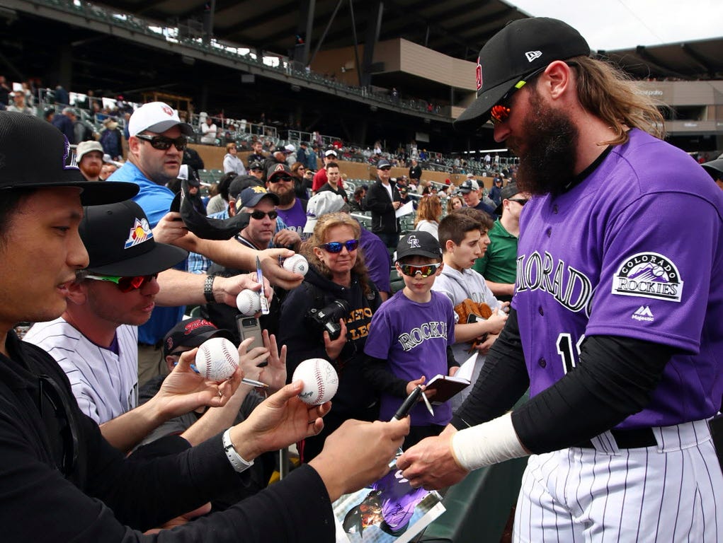 Colorado Rockies outfielder Charlie Blackmon signs autographs for fans prior to a spring training game against the Arizona Diamondbacks  in Scottsdale, Ariz.
