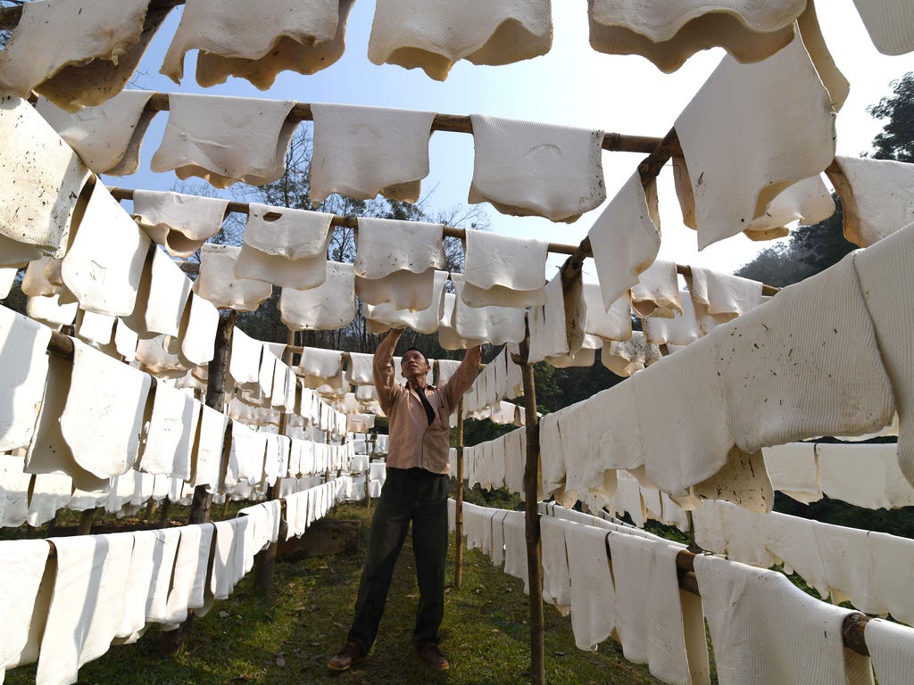 An Indian laborer hangs sheets of rubber to dry at a rubber farm in Thakurkuchi village on Jan. 14, 2018. The national Rubber Board is looking to make Assam one of the leading states in rubber production in the country. Kerala accounts for more than 