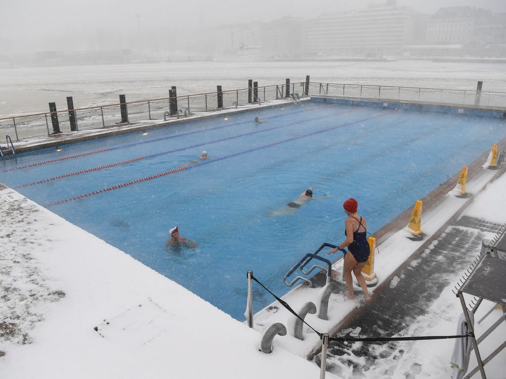People swim despite falling snow at the heated Allas Sea Pool, in frozen South Harbour in downtown Helsinki, Finland.