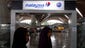 Passengers walk past a Malaysia Airlines sign at Kuala Lumpur International Airport.