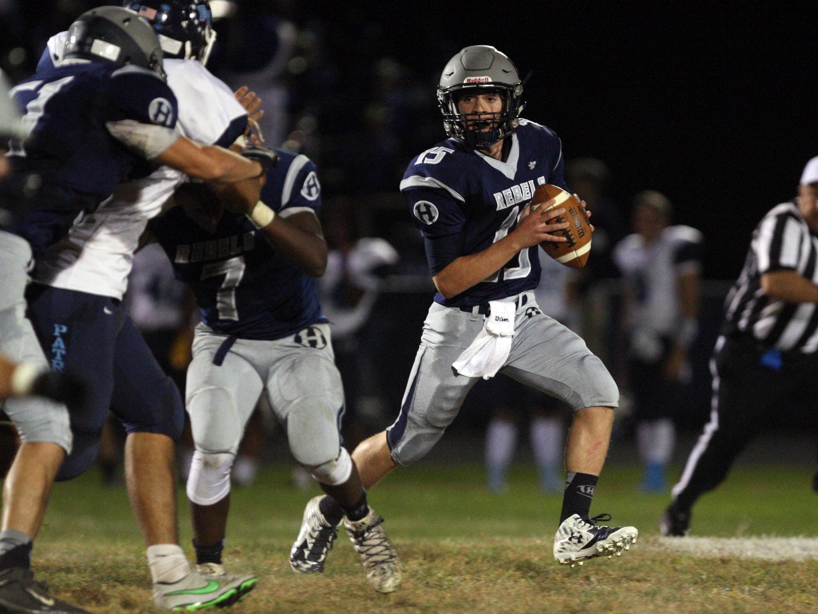 Quarterback Mark Iacobino, #15 Howell, scrambles with the ball as the Freehold Township defense chases him in a football game Friday, September 25, 2015, at Howell High School.