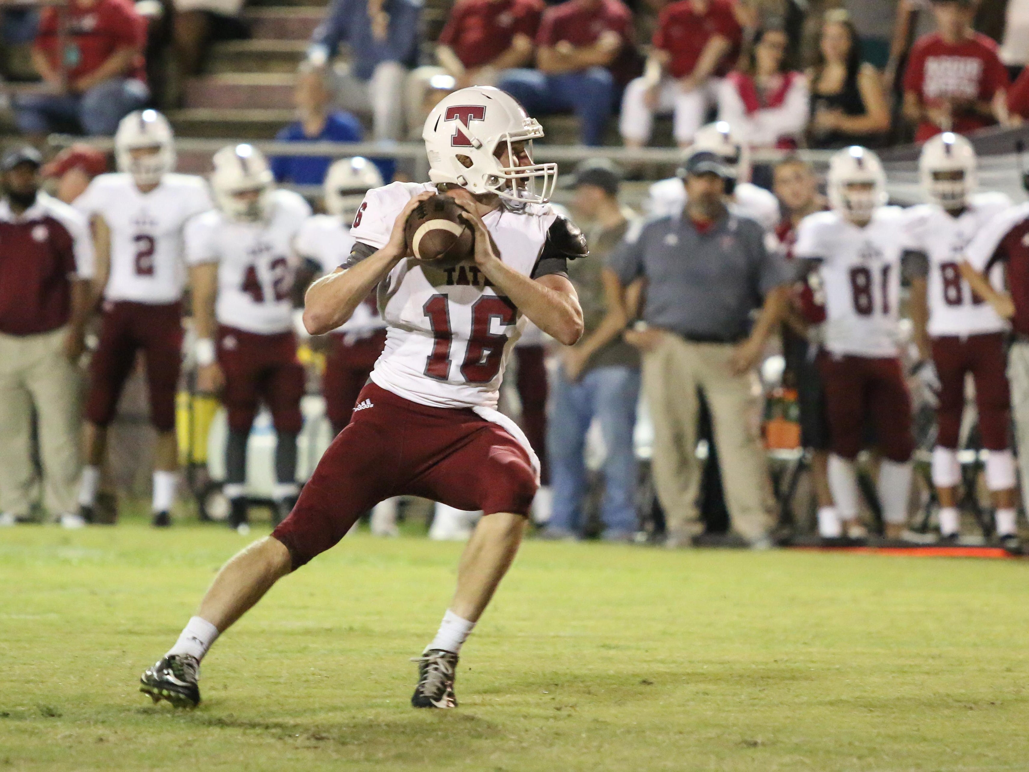 Tate quarterback Jake Henry (16) steps back and prepares to throw a touchdown pass to Rodriguez Smith during the opening drive of the game Friday night at Pensacola High School.