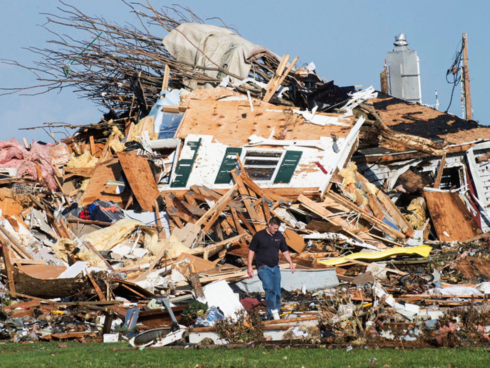 A man walks through a storm-damaged home in Gifford, Ill.
