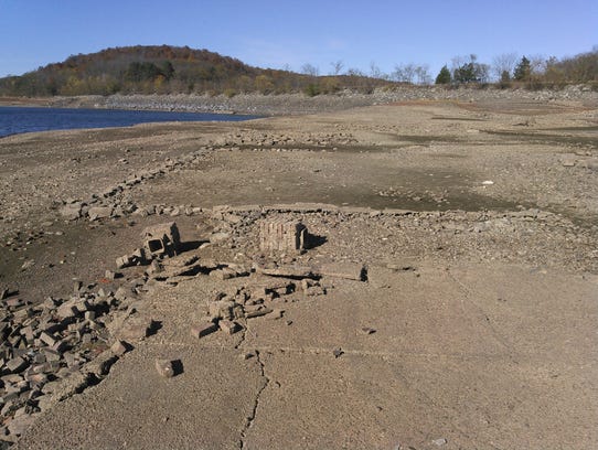 Foundations of old homes are now visible as water levels