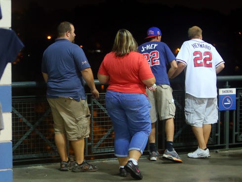 Baseball fans look over  a railing at Turner Field near the scene where a man fell  30-40  feet from the upper deck.