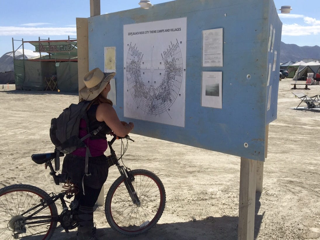 A Burning Man attendee checks an event map, which participants use instead of GPS on their smartphones.