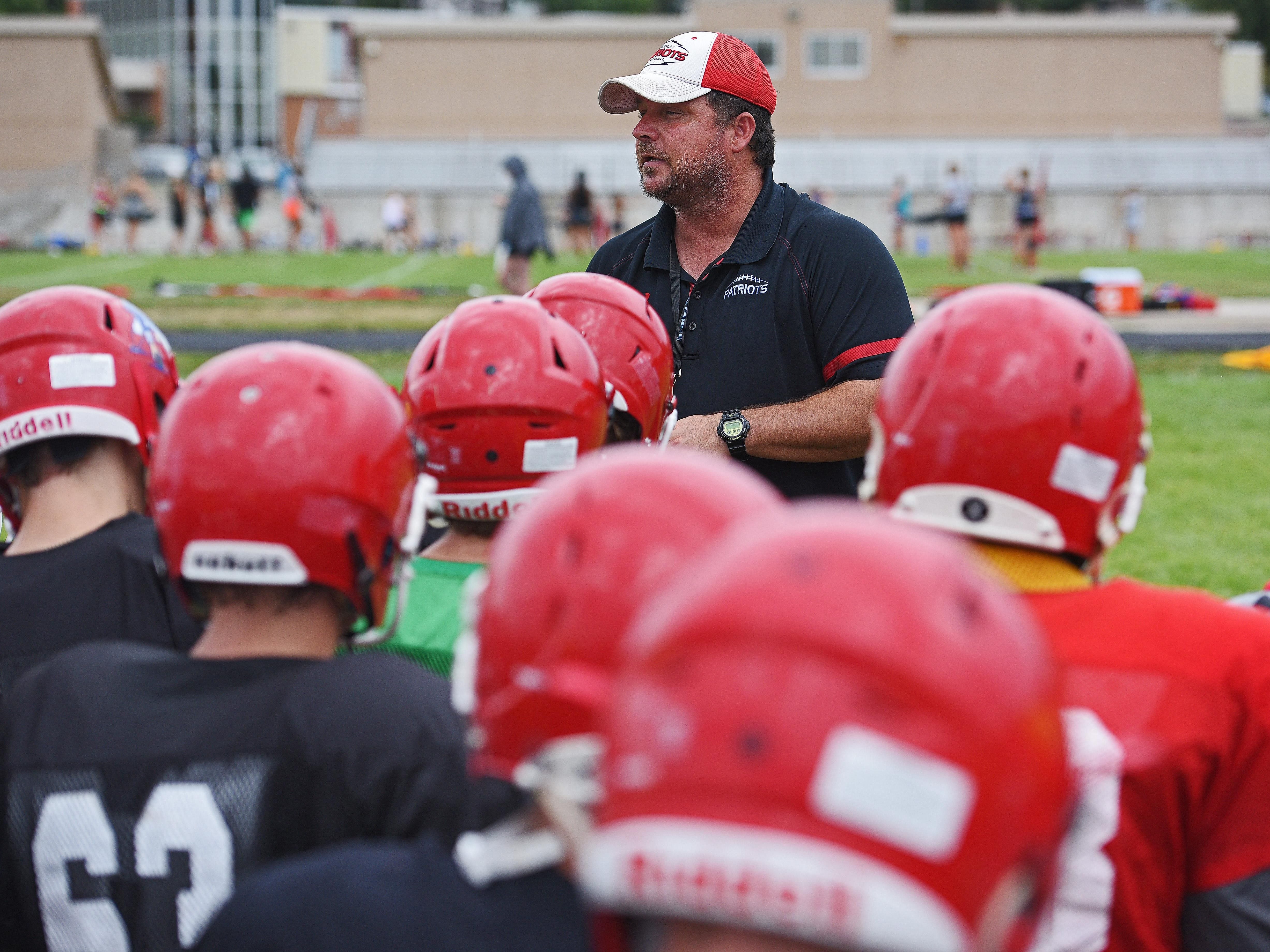 Lincoln High School football coach Aaron Beavers speaks to his team during a Lincoln High School football practice Thursday, Aug. 11, 2016, at Lincoln High School in Sioux Falls.