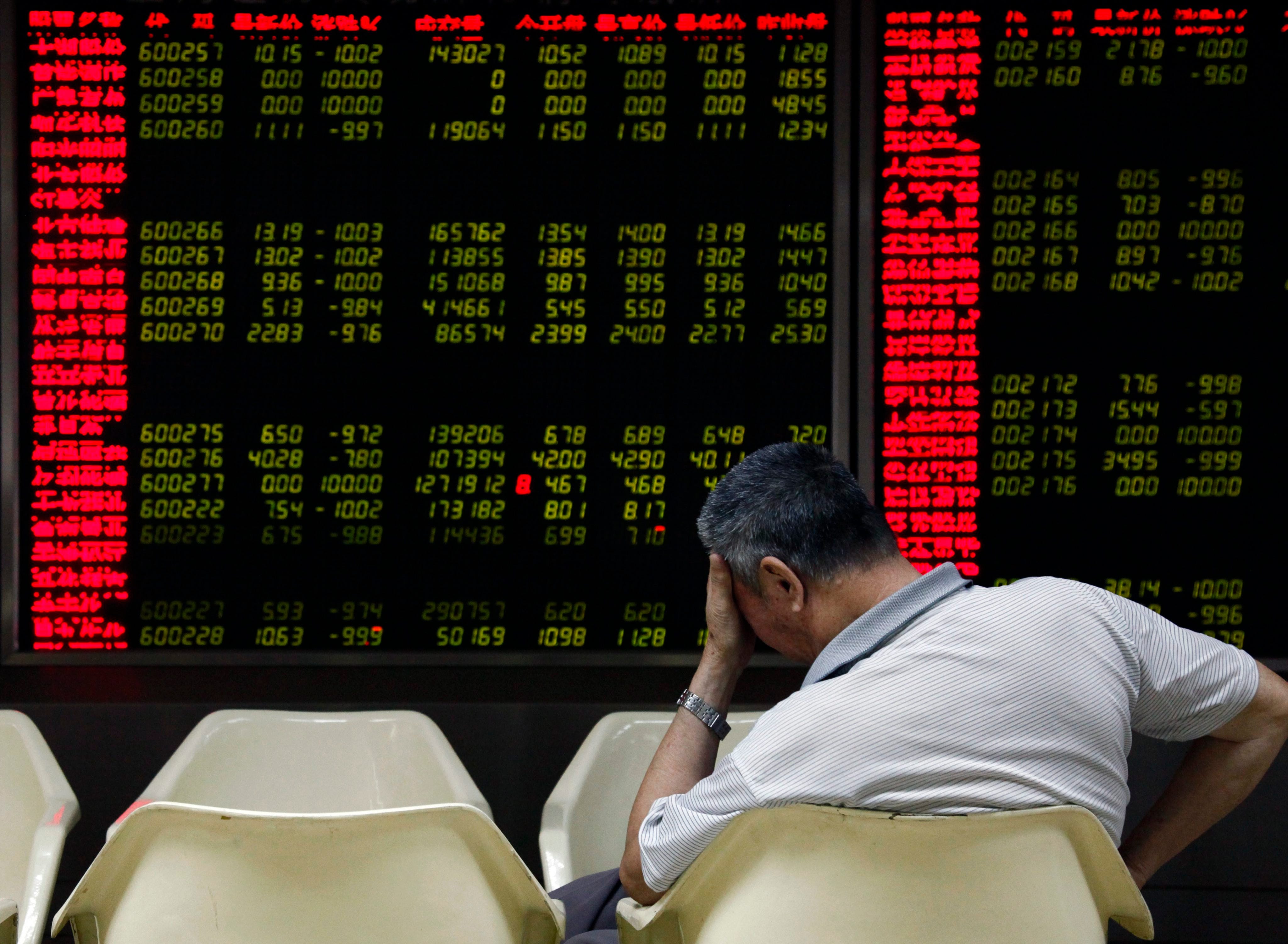 An investor reacts while monitoring stock data on an