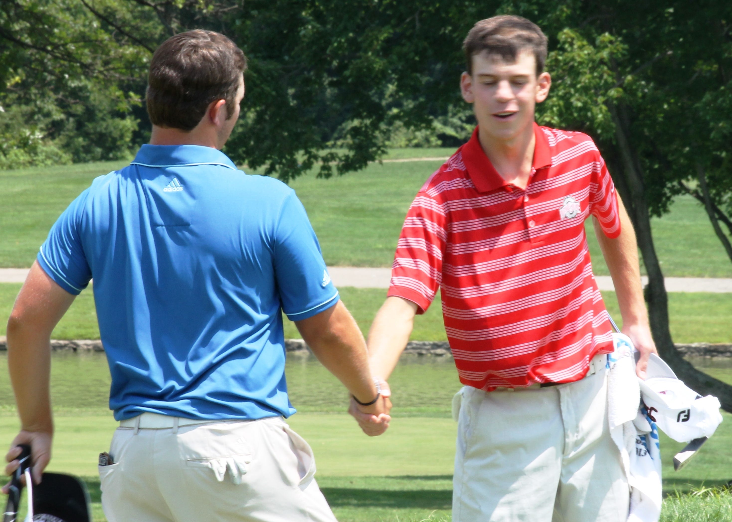 Ohio Amateur golf champion Andrew Dorn, left, shakes hands with runner-up Will Grimmer July 11 on the 18th green at Coldstream Country Club. Dorn needed a closing round of 66, five under par, to edge Grimmer 276-277 by one stroke in the four-day tournament.