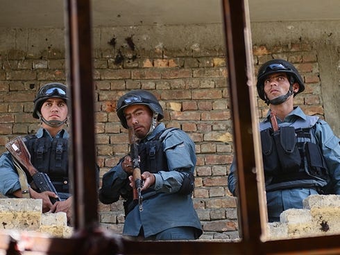 Afghanistan policemen stand guard in a building which was used for attack on Kabul airport in Kabul, Sunday.