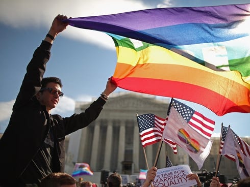 Eric Breese, left, of Rochester, N.Y., joins fellow George Washington University students and hundreds of others to rally March 27, 2013, outside the Supreme Court during oral arguments in a case challenging the Defense of Marriage Act.