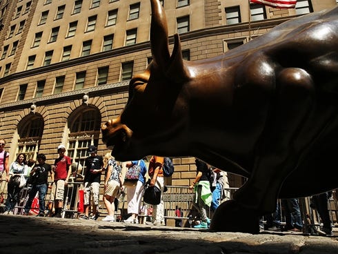 People wait in line to take a picture with the bronze bull in the Financial district which has become a Wall Street icon.