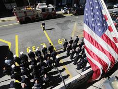 New York City firefighters of Engine 33, Ladder 9, observe a moment of silence during ceremonies for the 11th anniversary of the terrorist attacks in Lower Manhattan at the World Trade Center on Tuesday in New York City.