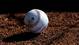 Detailed view of a baseball in the dirt during Angels camp at Tempe Diablo Stadium.
