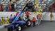 Track officials pull an engine out from the stands after a crash on the final lap of the DRIVE4COPD 300 at Daytona International Speedway.