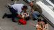 A pair of fans walk away as another fan is treated for injuries sustained from debris that went into the stands following a crash on the last lap of the DRIVE4COPD 300 at Daytona International Speedway.