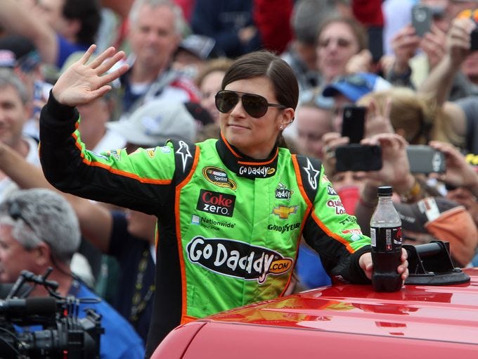Danica Patrick waves to the crowd as she is introduced before the 2013 Daytona 500 at Daytona International Speedway.